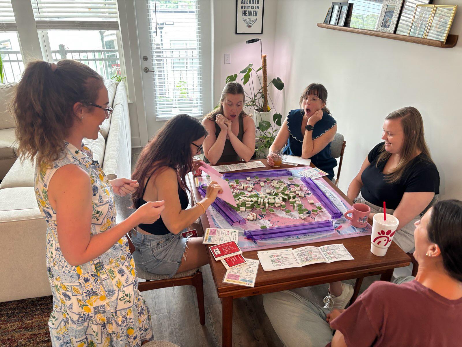 A group gathered around a table during a Palmetto Mahjong lesson